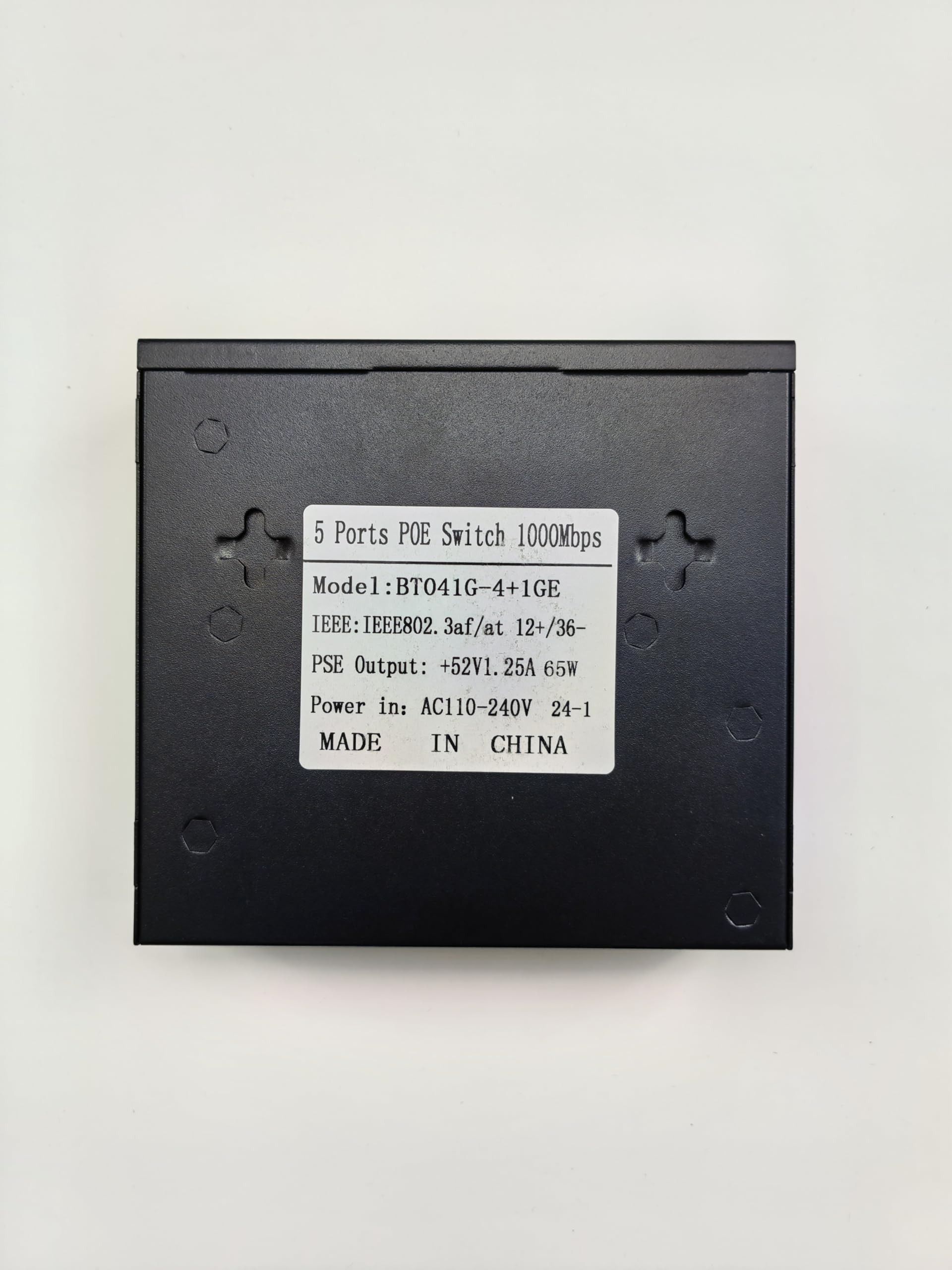 A black 5 Port Smart POE Switch with RJ45 ports, featuring a white label displaying technical specifications. Model BT04G-4+1GE from FIBAsource Ltd supports high-speed Ethernet switching and IEEE 802.3 af/at standards, offering a PSE output of +52V1.25A 65W and accepting power input ranging from AC110-240V 24-1. Made in China.