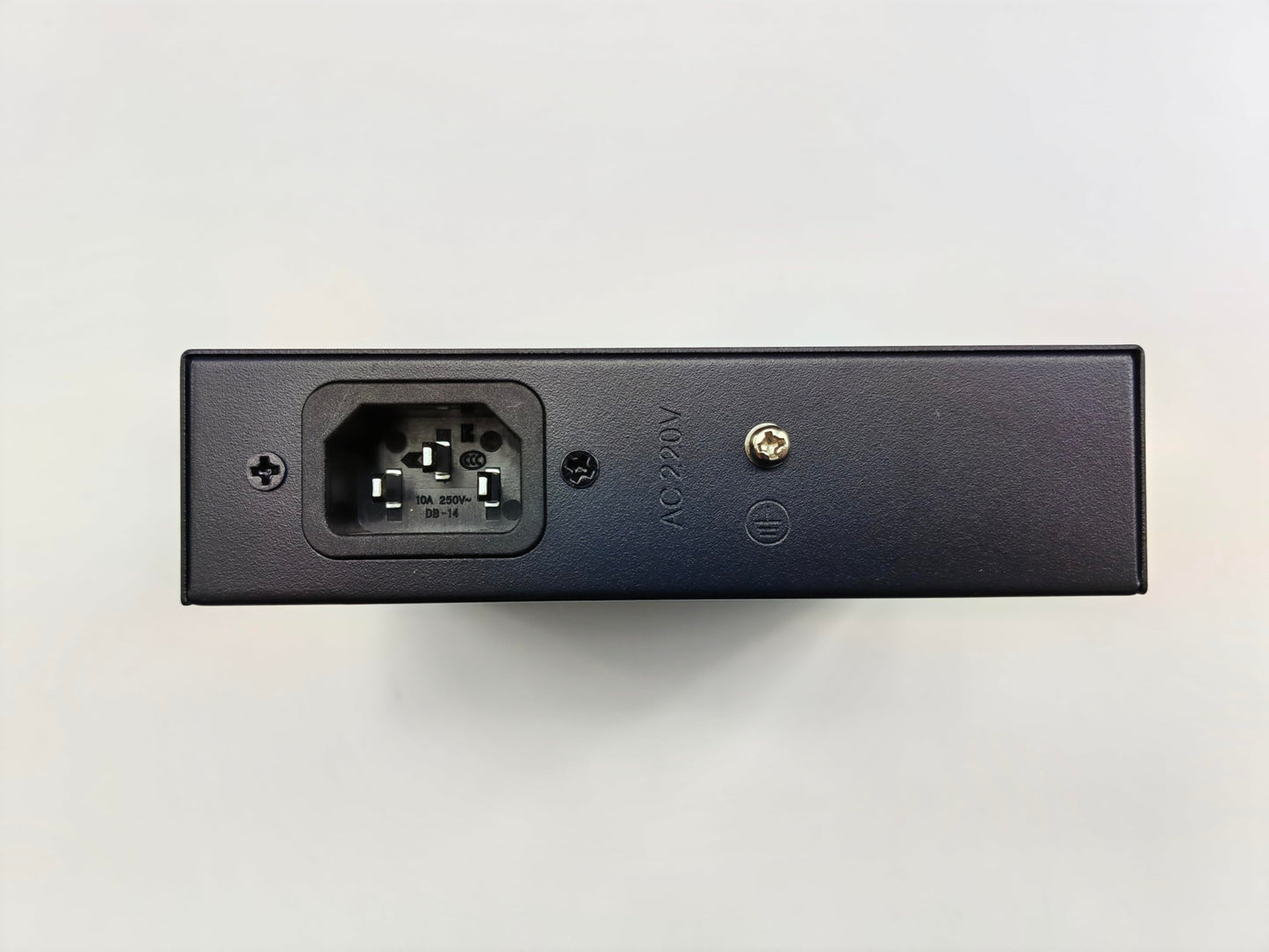 The FIBAsource Ltd 5 Port Smart POE Switch, model BT04G-4+1GE, is a sleek black rectangular device featuring an AC 220V power input socket and RJ45 ports along its side. Its smooth metallic surface reflects the high-speed Ethernet switching capabilities of this 10/100/1000 switch, all against a plain white background.