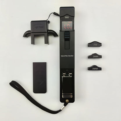 A FIBAsource Ltd Portable Optical Fibre Identifier Live Fibre Optic Cable Tester, featuring a black design with a digital display reading 0.0, is equipped with interchangeable heads marked 250, 2MM, and 3MM for diverse fiber network testing needs. It includes a detachable light hood and wrist strap, all elegantly displayed on a light surface.