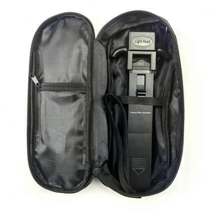 A Portable Optical Fibre Identifier Live Fibre Optic Cable Tester by FIBAsource Ltd is placed in an open black zippered case featuring a left compartment. Labeled with a Light Hood and 90D visible, it assists in optical signal detection. The interior is lined with dark fabric, making it ideal for fibre network testing essentials.