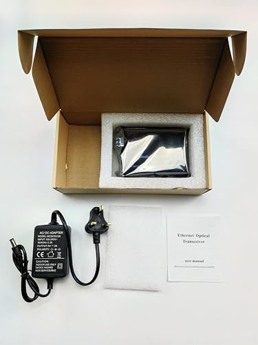 The cardboard box from FIBAsource Ltd contains a securely wrapped SFP Ethernet Media Converter with POE Function, along with a power adapter featuring a UK plug. A compact instruction manual labeled as an Ethernet Optical Transceiver, highlighting its low power dissipation and 100/1000Mbps transmission capabilities, is placed beside the adapter. The box also includes protective foam padding for added security.